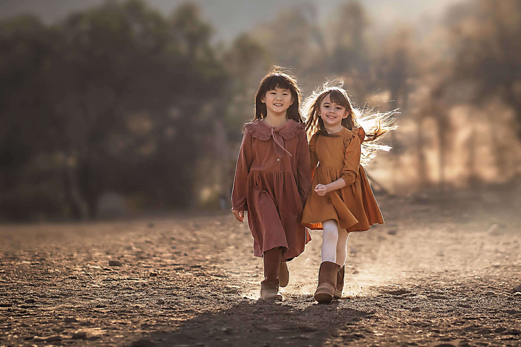 Dos hermanas caminando de la mano por un camino de tierra